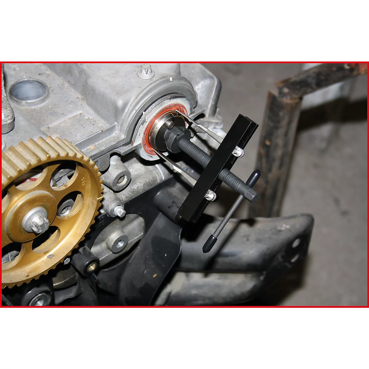 Nahaufnahme eines Motors mit Werkzeug. Goldene Zahnräder, schwarzes Werkzeug, roter Dichtungsring.